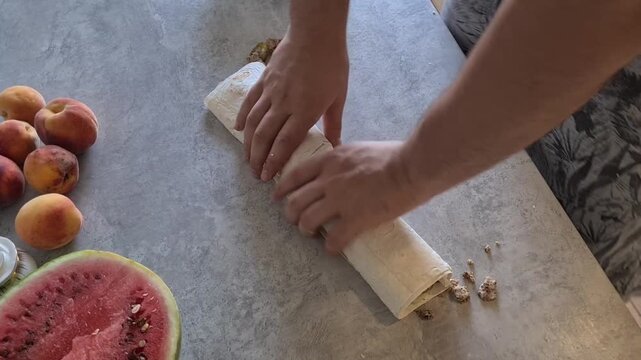 Making a wrap with fresh ingredients in a kitchen setting