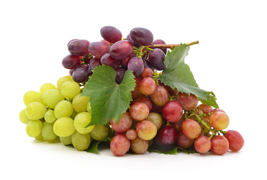 Fresh green, red, and purple grapes with green leaves isolated on a white background.