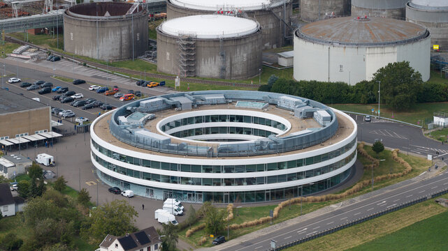 Aerial view of the circular office building at the Bayer chemical plant in Dormagen, surrounded by industrial storage tanks and parking lots in Koln, Nordrhein-Westfalen, Germany.