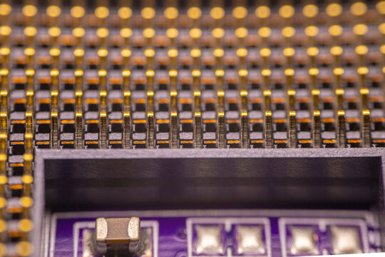Close-up view of a printed circuit board with gold-plated pins and electronic components, showcasing intricate details of the circuitry and soldering techniques