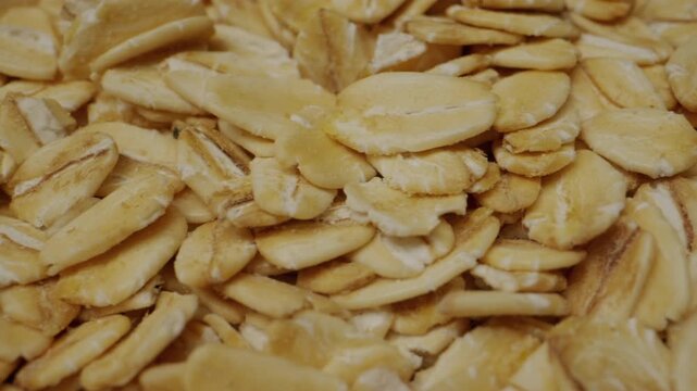 Macro close-up of raw rolled oat flakes. Concept of healthy food, cereals, breakfast and natural nutrition.