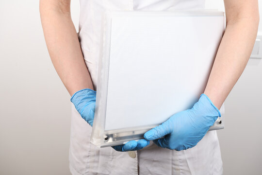 Medical worker in gloves holding blank folder isolated.