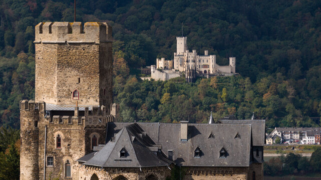 Aerial view of the historic Burg Lahneck castle with its stone tower and medieval architecture, set against lush green hills and a distant castle in Lahnstein, Rheinland-Pfalz, Germany.