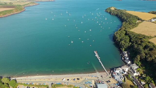 Aerial view of Dale Bay in Pembrokeshire, Wales, showing boats moored on calm blue water with green fields and coastline stretching into the distance