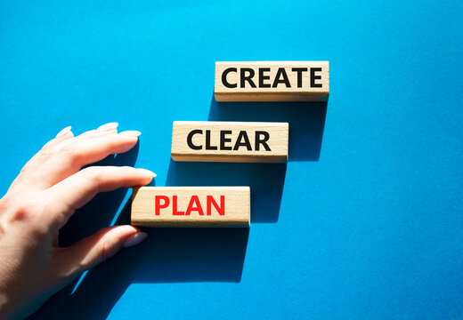 Concept words create clear plan on wooden blocks arranged as steps. Businessman hand arranging wooden blocks. Planning and decision making concept. Blue background. Copy space.
