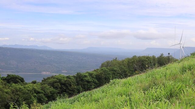 A scenic video view from the high-altitude wind turbine viewpoint at Khao Yai Thiang, Korat, Thailand, featuring beautiful scenery that overlooks the Lam Takhong Dam and wind energy infrastructure.
