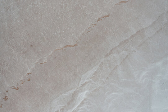 Aerial view of a vast arid landscape with subtle textures and faint tracks in Australia.