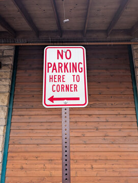 No parking here to corner sign with directional arrow