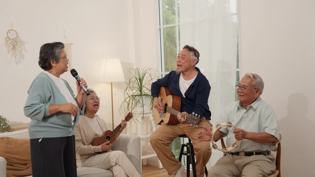 Elderly senior retirement lifestyle music group performance indoor living room community leisure happy social gathering with asian elder people playing guitar tambourine and ukulele bright home
