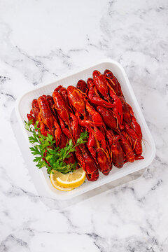 Freshly prepared crayfish with lemon and parsley, in a white disposable container, for freezing and transportation,