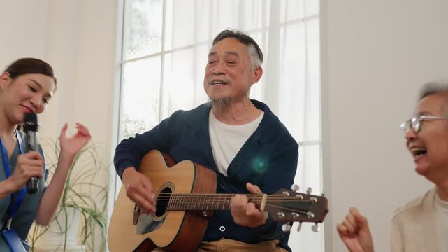 Senior retirement lifestyle elderly man playing guitar and singing with group in bright room, joyful music scene, indoor home leisure activity, smiling acoustic guitar duet and laughter