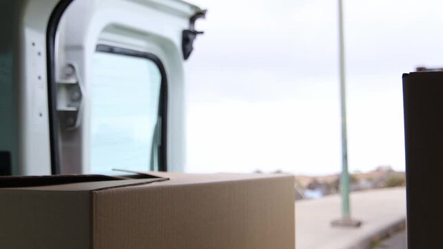 Delivery driver unloading boxes from his van