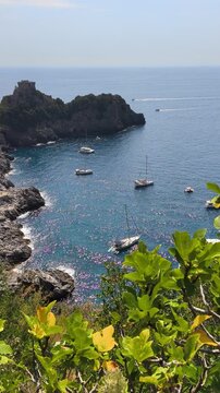 Vertical view of Conca dei Marini bay with anchored boats and Capo di Conca watchtower on the cliff, Amalfi Coast, Italy.