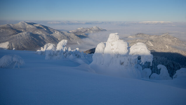 View of Borisov peak in the Velka Fatra mountains covered in deep snow and rime ice, with clear blue sky and distant mountain ranges, Velka Fatra mountains, Zilina Region, Slovakia.