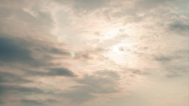 Moon shining through soft cloudy sky at dusk