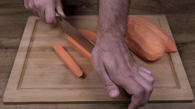 Slicing sweet potato on a wooden cutting board