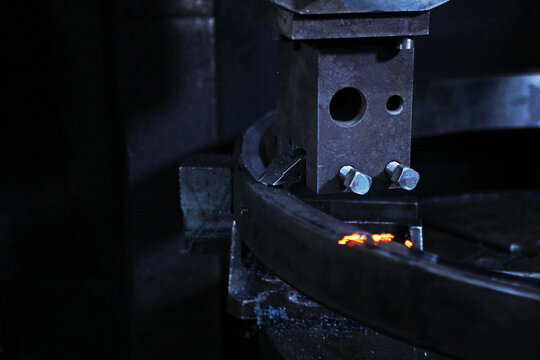 Machining bearing ring on machine tool. Grinding metal bearing ring on machine. Sparks and steel chips fly. Industrial manufacturing process