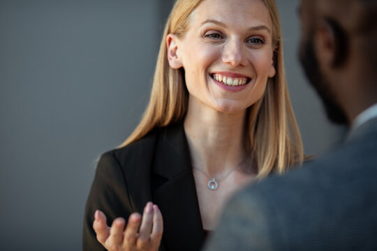 Smiling businesswoman talking with colleague indoors