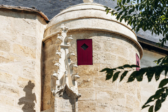 Neo-Gothic tower and ornate stone facade of Saint-Jean-Baptiste Church in Libourne, Nouvelle-Aquitaine, France.