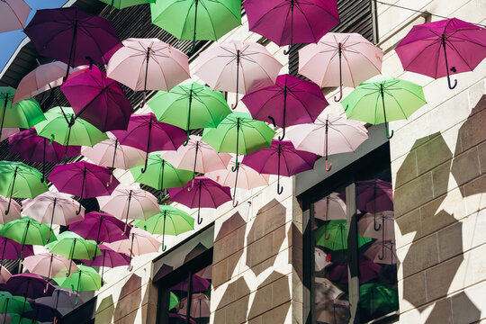 Colorful decorative umbrellas hanging above a street in central Bordeaux, France