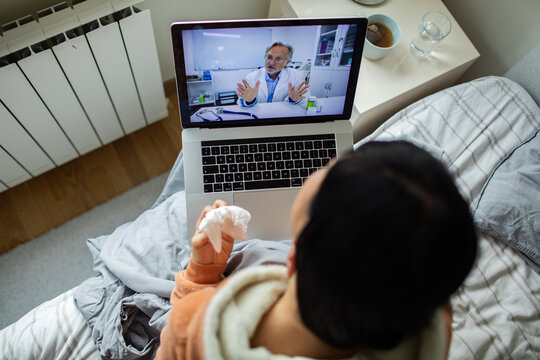 Sick patient consulting doctor via telehealth at home