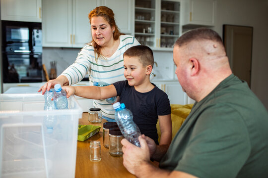 Family recycling plastic and glass at home kitchen