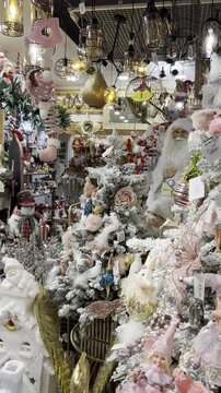 Maximalist Christmas decor in a festive ornament store with pink and white decorations, Santa figures, lights and holiday displays, illustrating seasonal retail and holiday shopping trends.