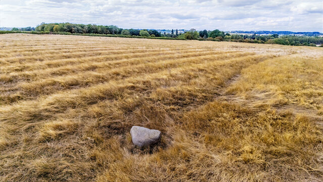 An aerial view past  the Judith Stone, a large glacial erratic block located in a ridge and furrow field in Lubenham, Leicestershire in summertime