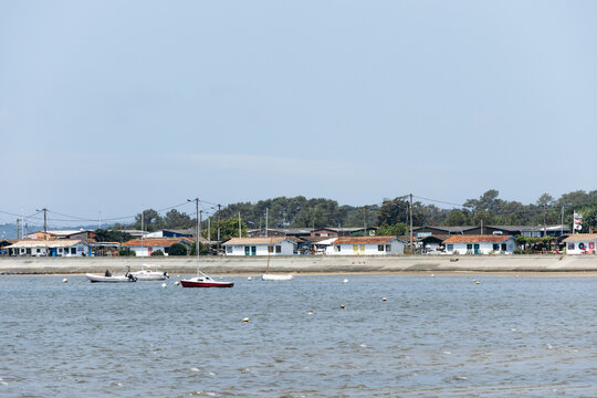 Andernos-les-Bains, France - July 10, 2026: Small boats and waterfront buildings along Arcachon Bay on a sunny summer day