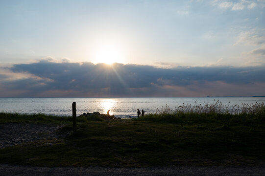 Sunset on a coast with a meadow and the sea.