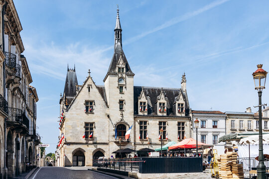 Libourne, France - July 14, 2026: Mairie de Libourne (Libourne Town Hall) decorated with French flags, with market stalls on the central square