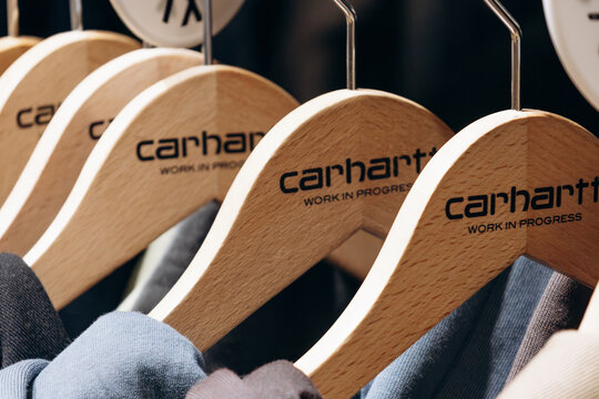 Bordeaux, France - July 14, 2026: Close-up of Carhartt Work In Progress branded wooden clothes hangers and apparel inside a Carhartt boutique in central Bordeaux