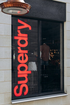 Bordeaux, France - July 14, 2026: Illuminated red Superdry logo on the window of the fashion retailer's store at Promenade Sainte-Catherine shopping center in central Bordeaux