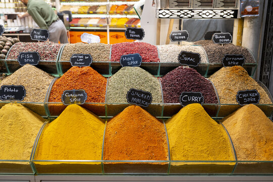 View of colorful mounds of various spices in glass containers with handwritten labels at the historic Spice Bazaar in Istanbul, Istanbul, Turkiye.
