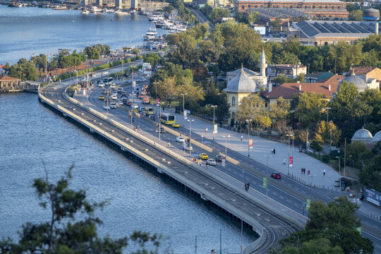 View of the coastal road along the Golden Horn with traffic, historic buildings, and lush trees in Istanbul, Istanbul, Turkiye.