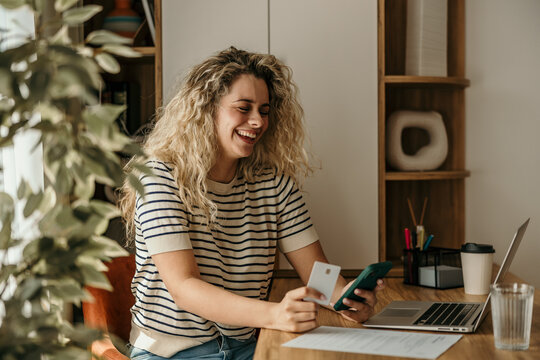 Woman smiling buying online using credit card and smartphone