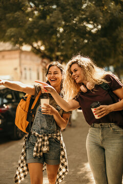 Friends exploring city street pointing discovering something exciting