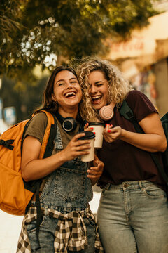Happy young women friends laughing together outdoors