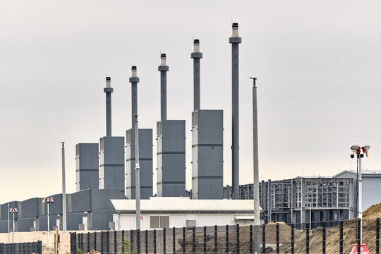 Taulov, Denmark - 28 August 2026: View of the Google Datacenter site featuring industrial backup power plants, tall exhaust stacks, and cooling infrastructure.