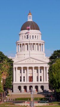 The California State Capitol building in Sacramento with clear skies and trees in the surroundings.