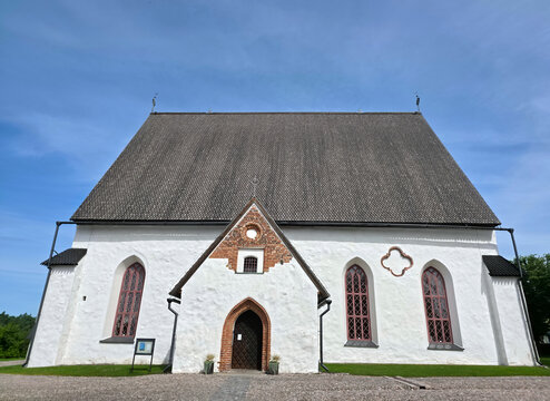 Porvoo, Uusimaa, Finland - 01 August 2026: View of Porvoo Cathedral, a historic medieval stone church with a steep shingled roof and white walls, set against a clear blue sky.