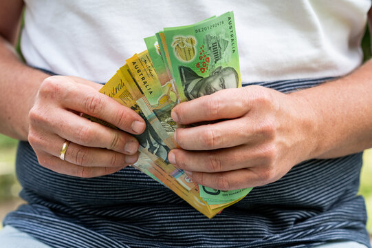Male Hands Holding and Counting Stack of Australian Dollar Bills for Business Finance Concept