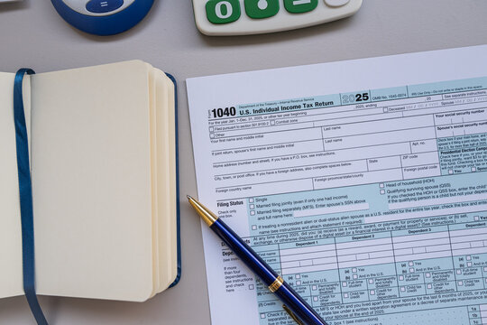 Tax Return Form 1040 Papers with Calculator Notebook and Pen for Personal Financial Planning