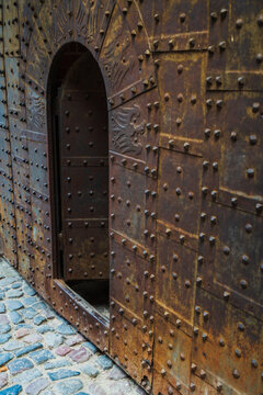 Malbork, Pomeranian Voivodeship, Poland - 23 March 2026: View of the historic metal-studded gate of the Teutonic Castle in Malbork with weathered iron plates and rivets.