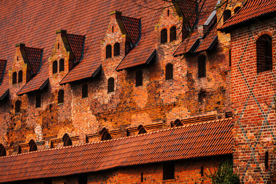 Malbork, Poland - 23 March 2026: View of the historic red brick walls and gabled roofs of Malbork Castle, showcasing medieval gothic architecture.