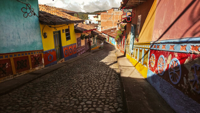 Guatape, Antioquia, Colombia - 13 September 2026: View of a colorful cobblestone street lined with traditional zocalos on the walls of houses in the historic town center.
