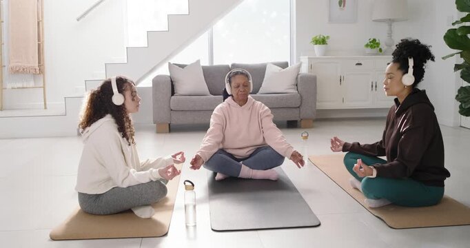 African American family women sitting on mats at home in headphones following audio opening smiles