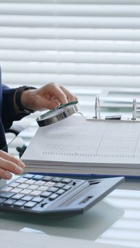 Business professionals collaborating on financial reports, calculating company expenses and income, managing accounting tasks, and preparing tax documentation in an office setting