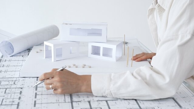 Architect reviewing blueprints and architectural drawings, designing new residential or commercial projects, developing urban planning and innovative construction concepts