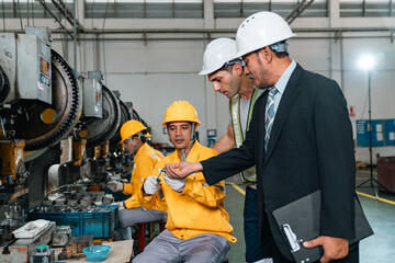 Fototapeta premium Industrial worker factory engineer inspection machinery safety helmet factory engineer inspecting machinery with industrial workers manufacturing facility, highlighting teamwork, safety